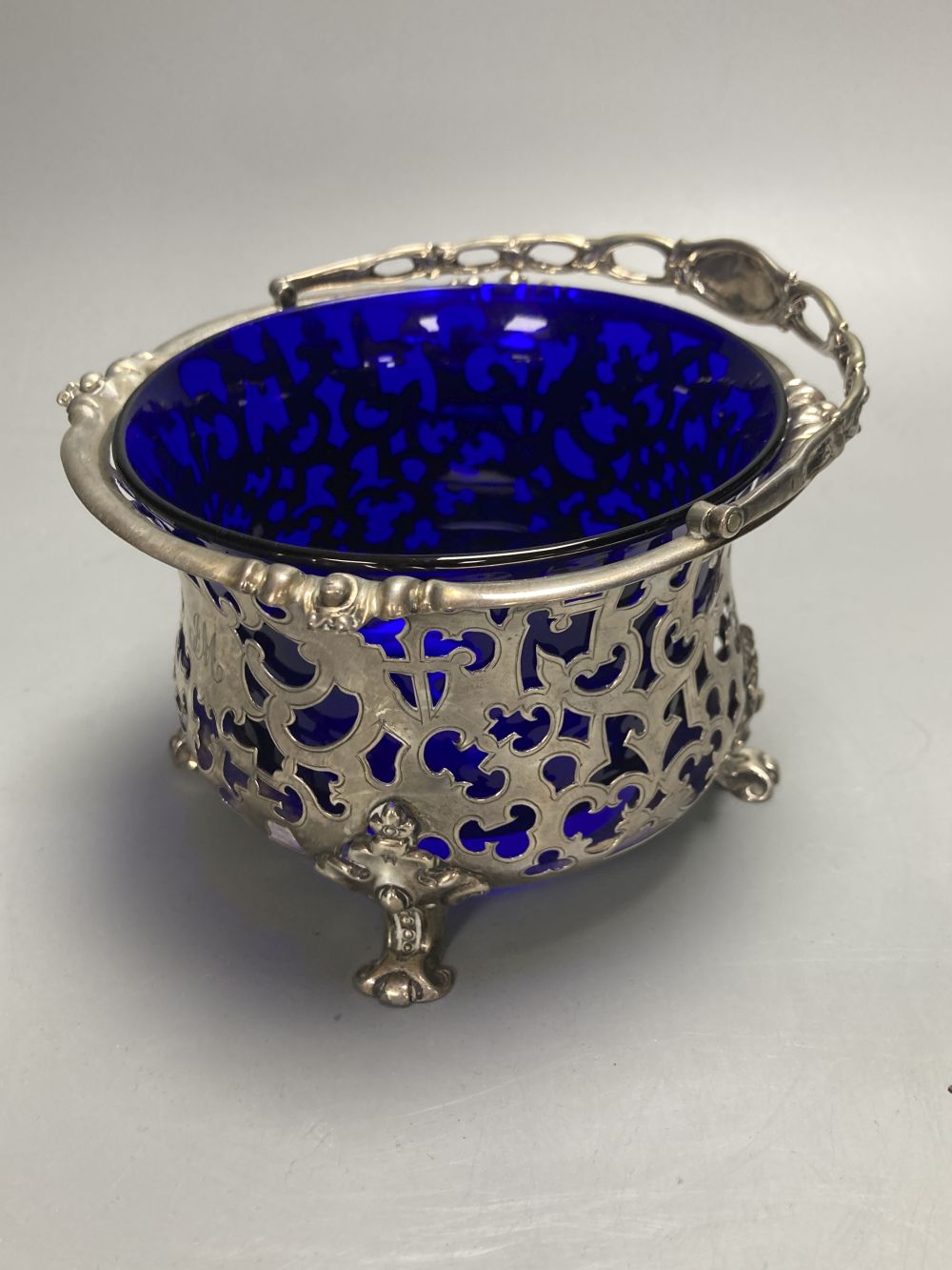 A Victorian pierced silver sugar basket with blur glass liner, George John Richards, London, 1850, height 9cm, 8oz.